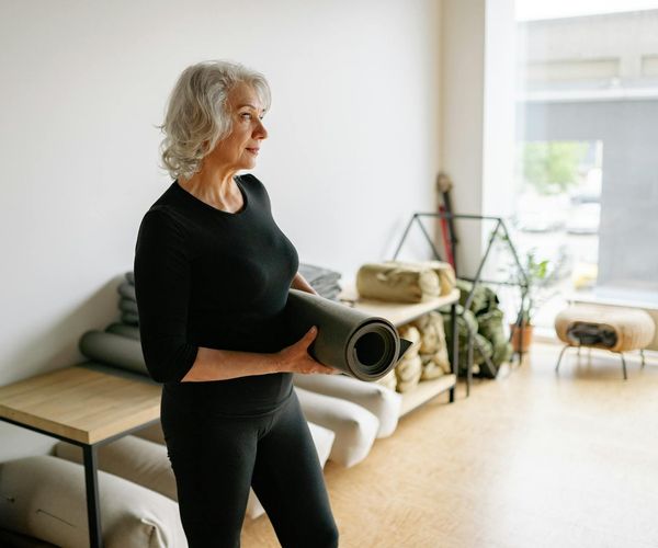 Person meditating peacefully in a brightly lit, minimalist room.