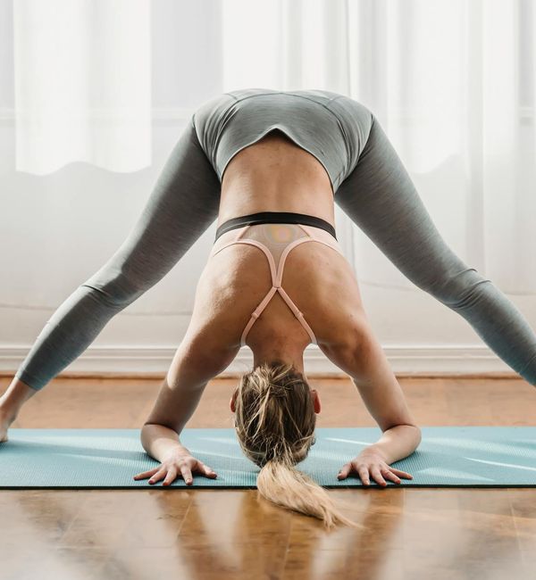 Woman in a calm yoga pose in a dark room with emerald light.